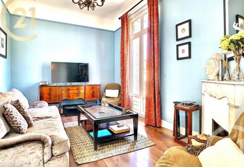 un salon avec un canapé et une télévision dans l'établissement Chez Grace, à Cannes