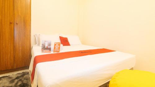 a bedroom with two beds and a yellow chair at RedDoorz at V-Cloud Hills near De La Salle Dasmarinas Cavite in Dasmariñas