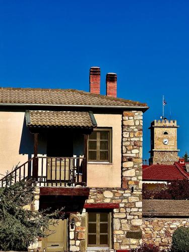 a building with a clock tower on top of it at Oikies Art Rooms in Ángistron