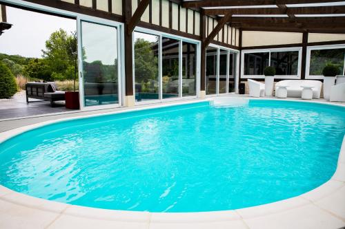 - une piscine à débordement dans une maison dotée de baies vitrées dans l'établissement Villa des Saules, à Le Bec-Thomas