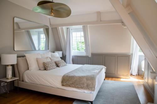 une chambre avec un lit blanc et un grand miroir dans l'établissement Villa des Saules, à Le Bec-Thomas