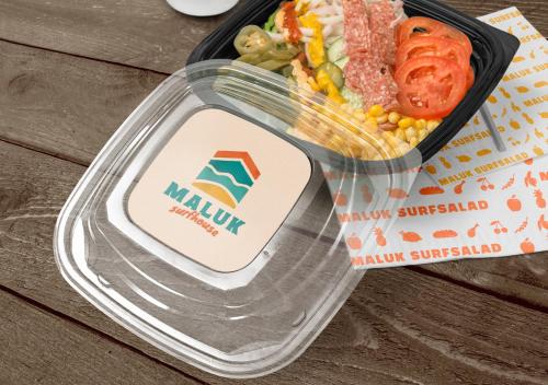 a plastic container of food with meat and vegetables at Maluk Surf House in Maluk