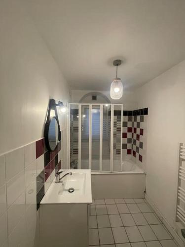 une salle de bain avec un lavabo et une baignoire dans l'établissement L'inouï - Bailly Loc, à Bourges