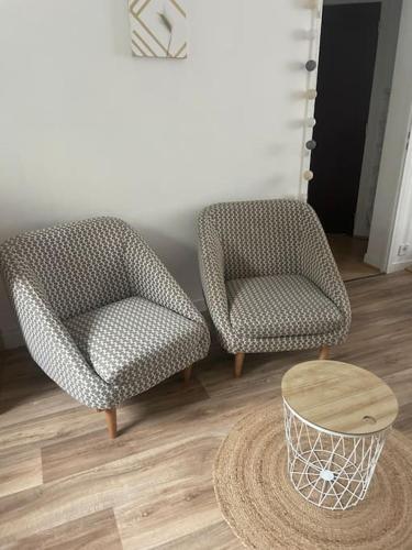 deux chaises et une table dans une pièce dans l'établissement L'inouï - Bailly Loc, à Bourges