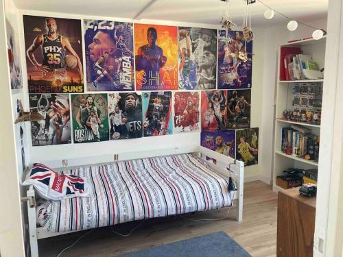 Cette chambre comprend un lit avec des affiches murales. dans l'établissement Maison avec jardin proche de Paris et du métro, à Montreuil