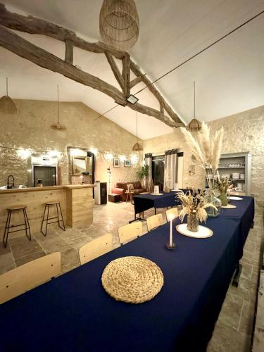 - une longue table bleue dans une pièce avec cuisine dans l'établissement La Palombière, à Saint-Clar