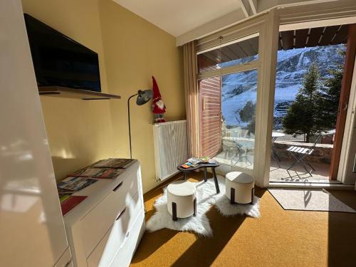 un salon avec une grande fenêtre avec vue dans l'établissement Petit cocon au cœur de la Mongie, à Bagnères-de-Bigorre