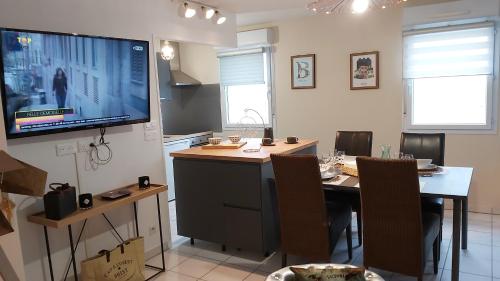 a kitchen with a table and a tv on the wall at L'escale N°13 :Appartement standing dans résidence in Brest