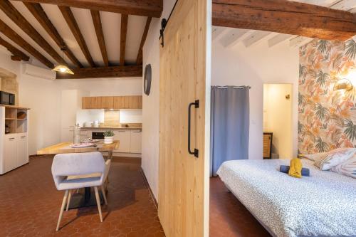 a bedroom with a bed and a desk and a kitchen at Le Nostradamus - Hypercentre - Clim - Wifi in Saint-Rémy-de-Provence