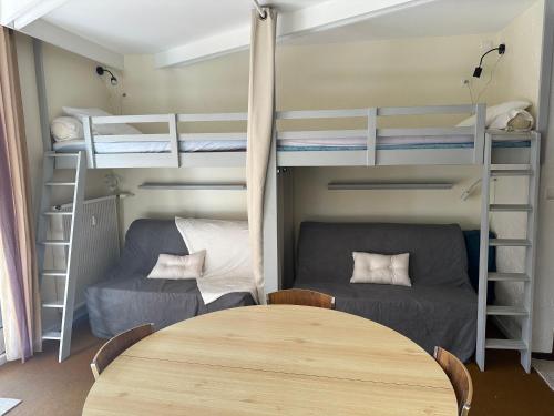 une chambre avec deux lits superposés et une table dans l'établissement Petit cocon au cœur de la Mongie, à Bagnères-de-Bigorre