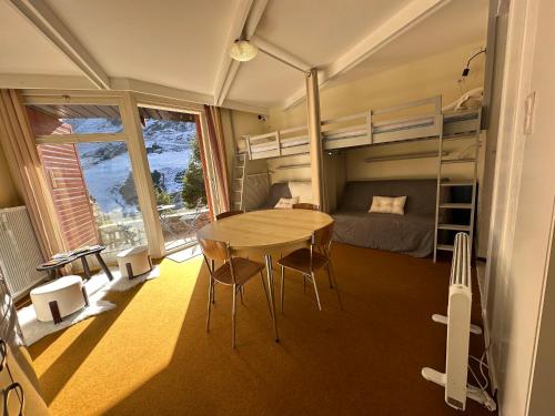 Cette chambre comprend une table et des lits superposés. dans l'établissement Petit cocon au cœur de la Mongie, à Bagnères-de-Bigorre