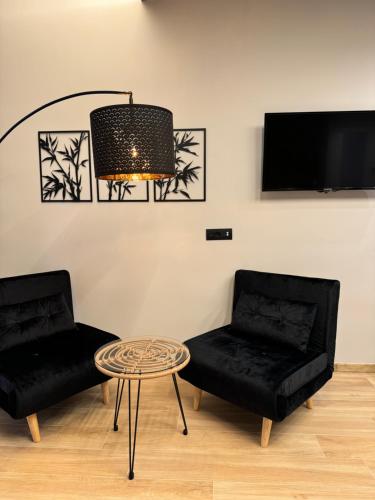 a living room with two black chairs and a table at Eterna Suites Roma in Rome