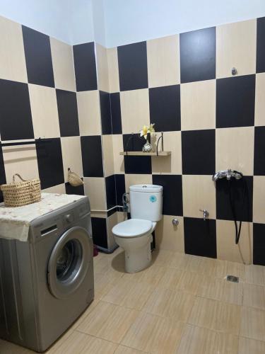 a bathroom with a toilet and a washing machine at Appartement spacieux avec terrasse à 10 minutes du centre in Tangier