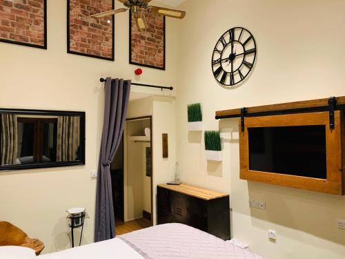 a bedroom with a bed and a clock on the wall at The Bull Inn Pub in Stanford Dingley