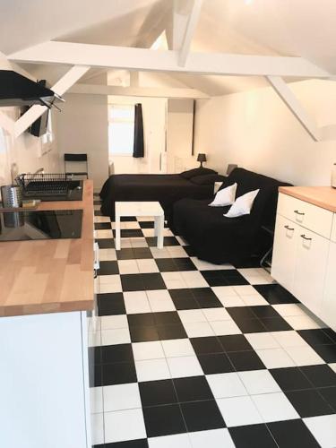 - un salon avec un canapé noir et un sol en damier dans l'établissement À cabin on town, à Choisy-le-Roi