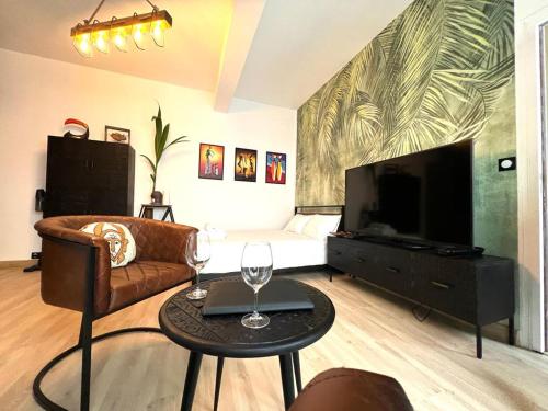 un salon avec un canapé, une télévision et une table dans l'établissement L'Ethnique - Hypercentre - Gare, à Angers