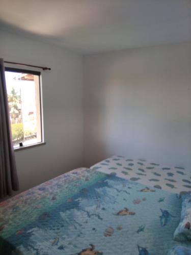a bedroom with a bed and a window at Apartamento em guarajuba 200m da praia in Camaçari