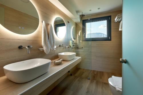 a bathroom with a large white sink and mirrors at Sentido Kyknos Beach Adults Only in Malia