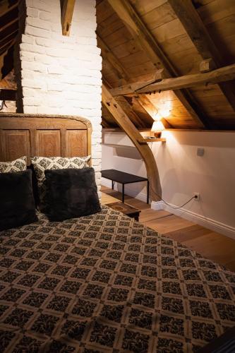 a bedroom with a large bed in a attic at Het Ovenhuisje in Denderwindeke