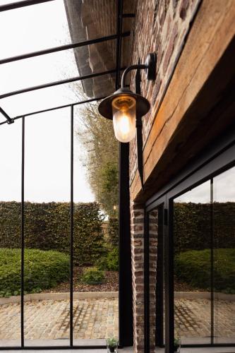 a ceiling light hanging from a building with windows at Het Ovenhuisje in Denderwindeke