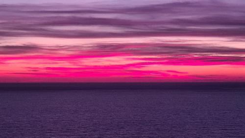 a sunset over the ocean with a pink at Uğrak Home in Işıklı