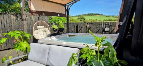 a hot tub on a patio with plants at The Green Monkey Lux Suite at The Grumpy Schnauzer B&B Private Hot Tub, Gym, Breakfast, Stunning! in New Monkland