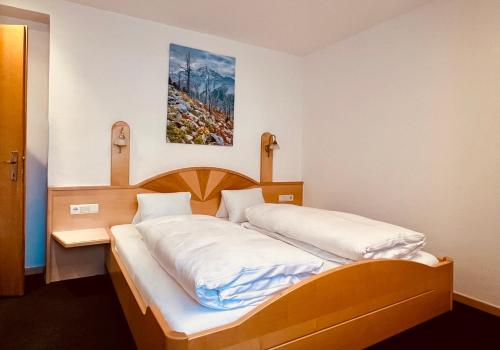 two twin beds in a room with a picture on the wall at Haus Lena in Solda