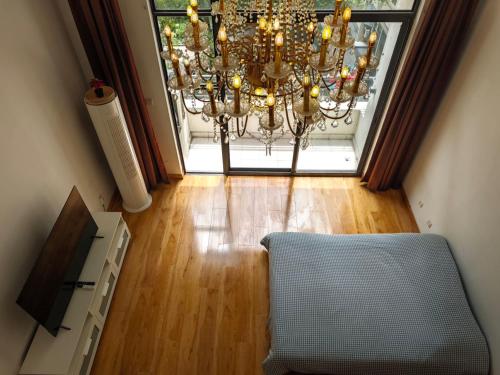 a chandelier in a living room with a chair at iNestin Shanghai Apt Xinjinqiao Road in Shanghai