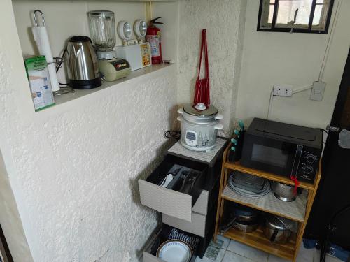 a kitchen with a microwave and a coffee maker on a shelf at Cozy Townhouse own parking Wi-Fi in Baguio