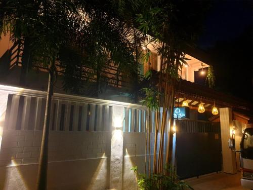 a house at night with palm trees and lights at Lanka Villa Mirissa in Mirissa