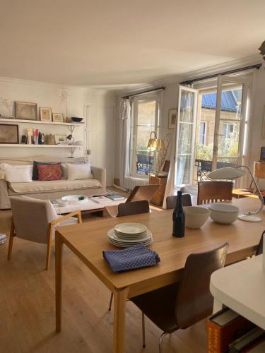 un salon avec une table et un canapé dans l'établissement Appartement à deux pas du canal Saint Martin, à Paris