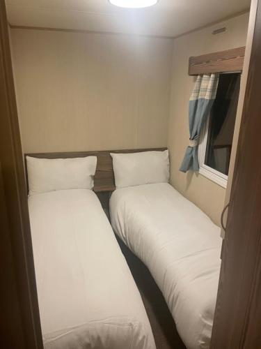 two beds in a small room with a window at 25 cherry tree in Gristhorpe
