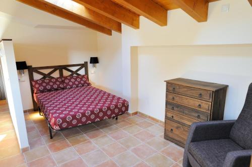 a bedroom with a bed and a chair and a dresser at Apartaments Cal Climent in Fornols