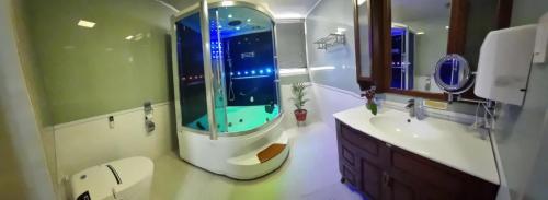 a bathroom with a shower with a toilet and a sink at Baguio Brentwood Villas in Baguio