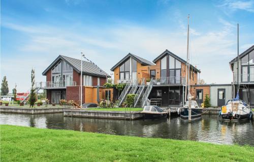 a group of houses on a river with boats in the water at La Felicidad in Stavoren