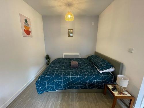 a bedroom with a bed with a blue comforter at Jim's place in Bristol