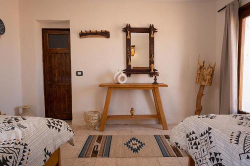 a room with a mirror and a table with two beds at Sukoon Nuweibaa in Nuweiba