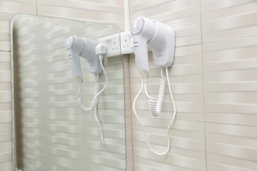 un par de teléfonos blancos colgando en una pared en Diamond Delight Boutique Hotels, en Moshi