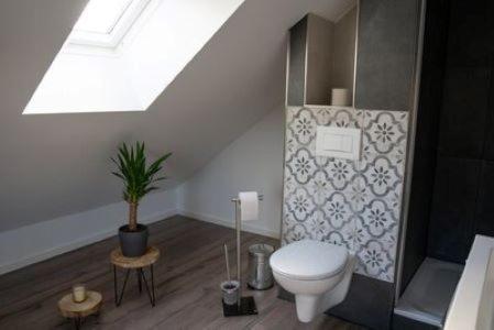 a bathroom with a toilet and a plant at Zentrale Ferienwohnung in Bielefeld