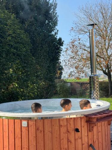 three boys in a hot tub in a backyard at Hotel Fondo Catena in Ferrara