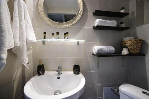 a bathroom with a sink and a mirror and towels at loft apartment in Athens