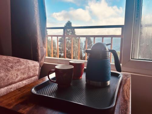 a tray with two cups on a table next to a window at Lava Hills Heaven Homestay in Lava