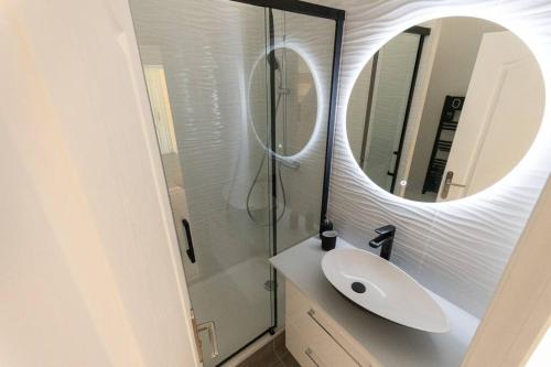 une salle de bain avec un lavabo et un miroir dans l'établissement L'Exotique - Hypercentre - Gare, à Angers