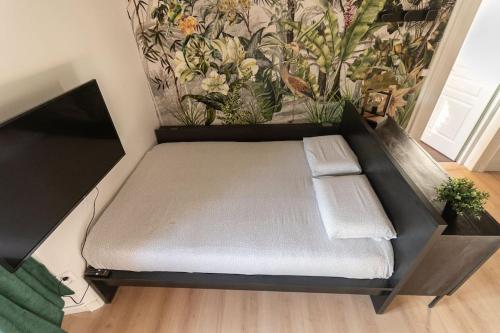 - un petit lit dans une chambre avec un mur dans l'établissement L'Exotique - Hypercentre - Gare, à Angers