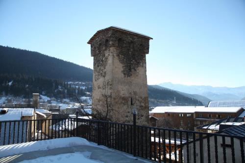 an old tower on a balcony with snow on the ground at Guesthouse David Zhorzholiani in Mestia