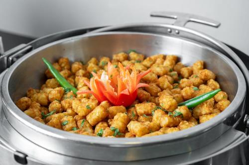 a pot of food with vegetables on top of a stove at Elaf Bakkah Hotel in Makkah