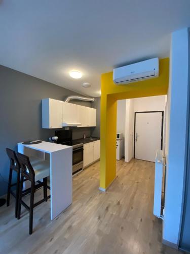 a kitchen with a table and chairs and a yellow wall at FIAOR Apartment, 1-2 guests, Free Parking & Wifi, 7 km Downtown, Bratislava in Bratislava