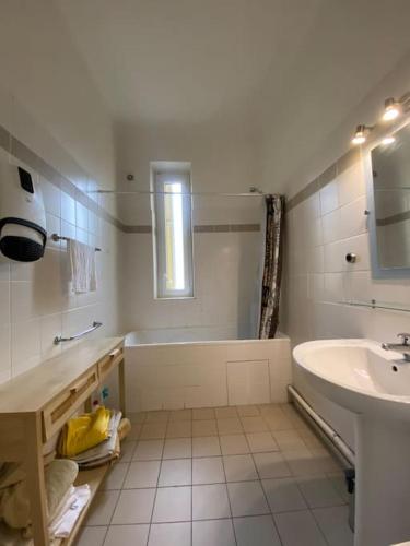 une salle de bain blanche avec une baignoire et un lavabo dans l'établissement appartement Cyrnos 3Pc 73m2, à Ajaccio