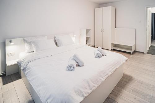 a bedroom with a large white bed with towels on it at SEB Residence Sibiu II in Sibiu