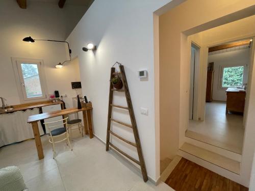 a room with a ladder next to a table and a desk at Due Di Tutto in Ferrara